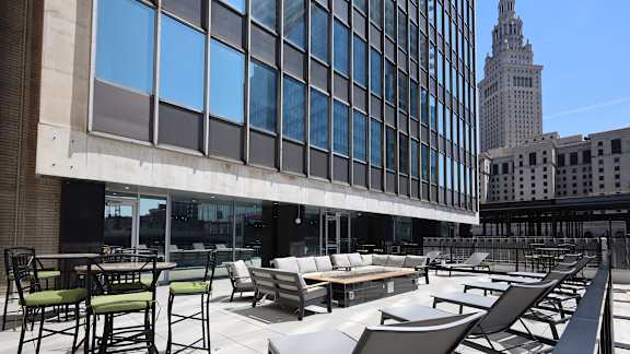 A rooftop patio with chairs and tables.