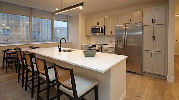 A kitchen with a white countertop and stainless steel appliances.