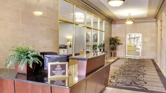 A reception desk with a plant and a sign that says "Pinnacle".