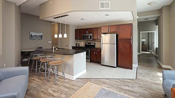 A kitchen with a bar and stools.