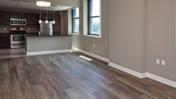 A kitchen with a wood floor and a window.