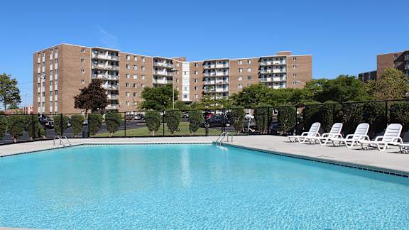 A swimming pool in front of apartment buildings.