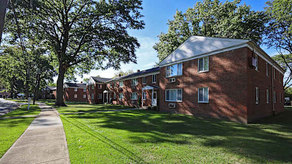 A red brick building with a green lawn in front.