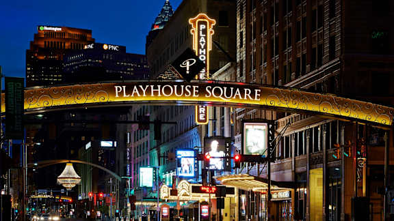 The Playhouse Square sign is lit up at night.