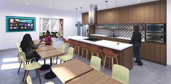 A woman is sitting at a table in a modern kitchen.