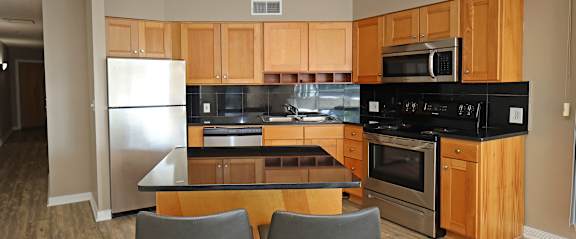 A kitchen with wooden cabinets and black appliances.