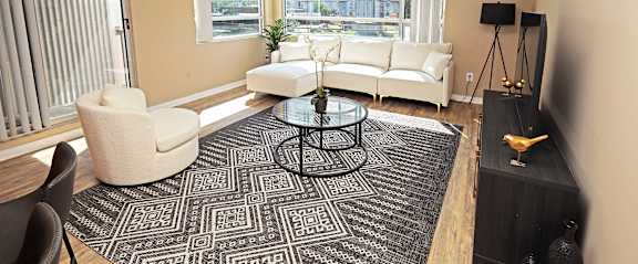 A living room with a white sofa and a glass coffee table.