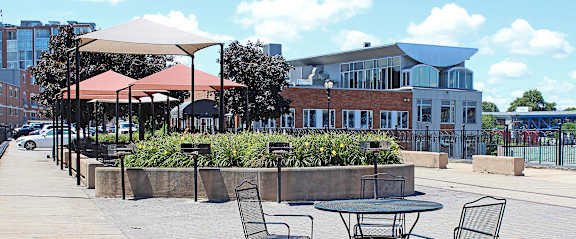 A patio with a table and chairs and a red umbrella.