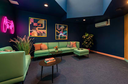 a living room with green couches and a tv