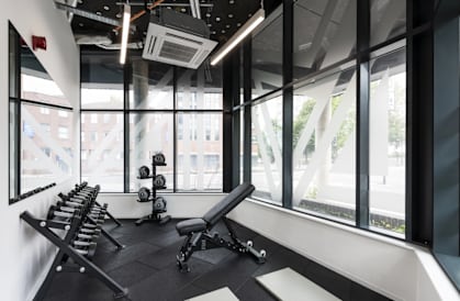 a workout room with weights and windows in a building