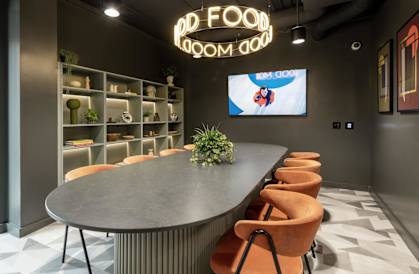 a large table in a room with chairs and a tv