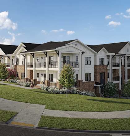 a row of townhouses on a street with grass