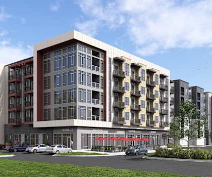 A modern apartment building with a parking lot in front.