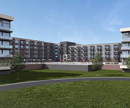 A row of modern apartment buildings with green lawns in front.