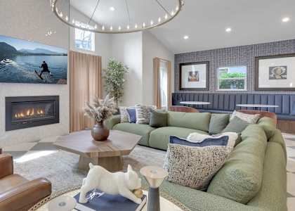 A living room with a fireplace and a painting of a person surfing.