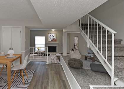 a living room and dining room with a staircase