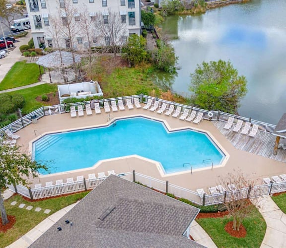 A large swimming pool surrounded by a white fence. at The Villages on Millenia Apartments, Orlando, FL, 32839
