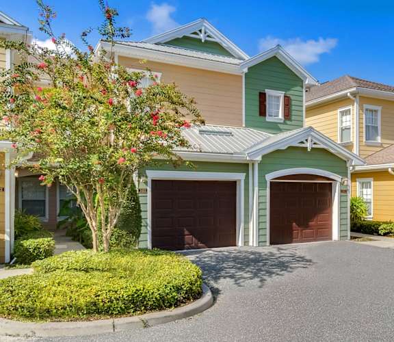 a house with a driveway and two garages in front of it
