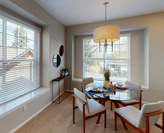 A modern dining room with a glass table set for two.