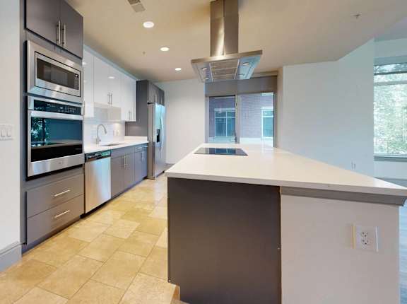 A modern kitchen with a large island and stainless steel appliances.