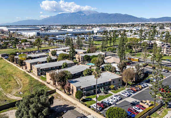 A view of a parking lot with cars and a building in the background. at Heritage Park, Rialto, CA