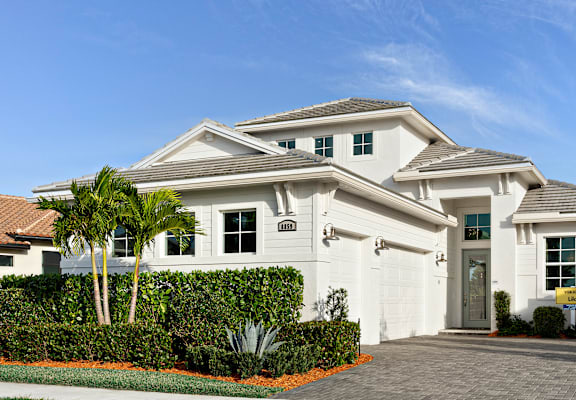 A white two-story house with a garage and a driveway.
