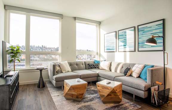 A living room with a grey couch and a wooden coffee table.at Axle, Seattle, 98119