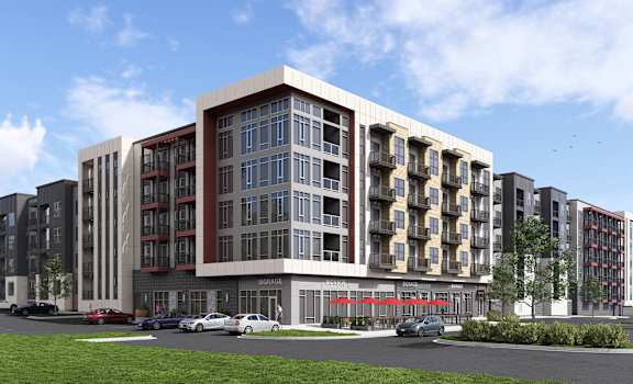 A modern apartment building with a parking lot in front.