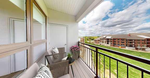 A balcony with a couch and a table with flowers on it.