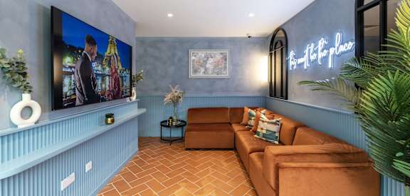 a living room with blue walls and a brown couch