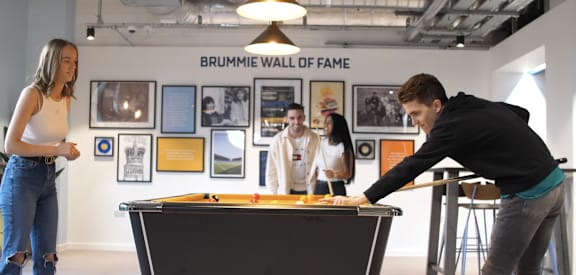 a group of people playing a game of pool on a table
