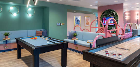 two billiards tables in a game room with pool tables