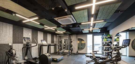 a gym with various exercise equipment on the floor and a window