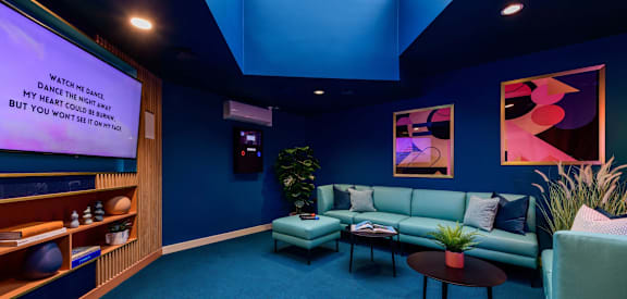 a room with blue walls and blue couches and a tv