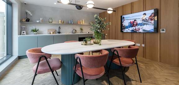 a dining room with a table and chairs and a tv