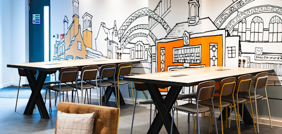 a restaurant with tables and chairs and a mural on the wall