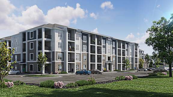 A modern apartment building with a parking lot in front.