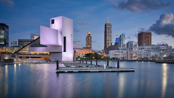 A modern building with a unique design is situated on the waterfront.