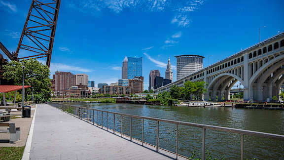 A walkway with a metal railing runs alongside a body of water.
