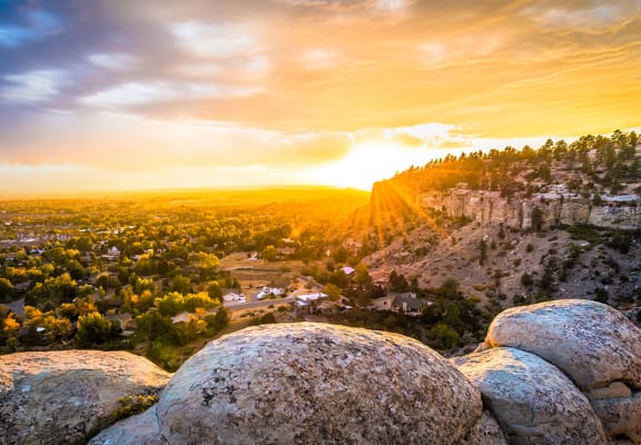 a view of the sunset over a city from a rocky hill at Rock Creek, Montana, 59102
