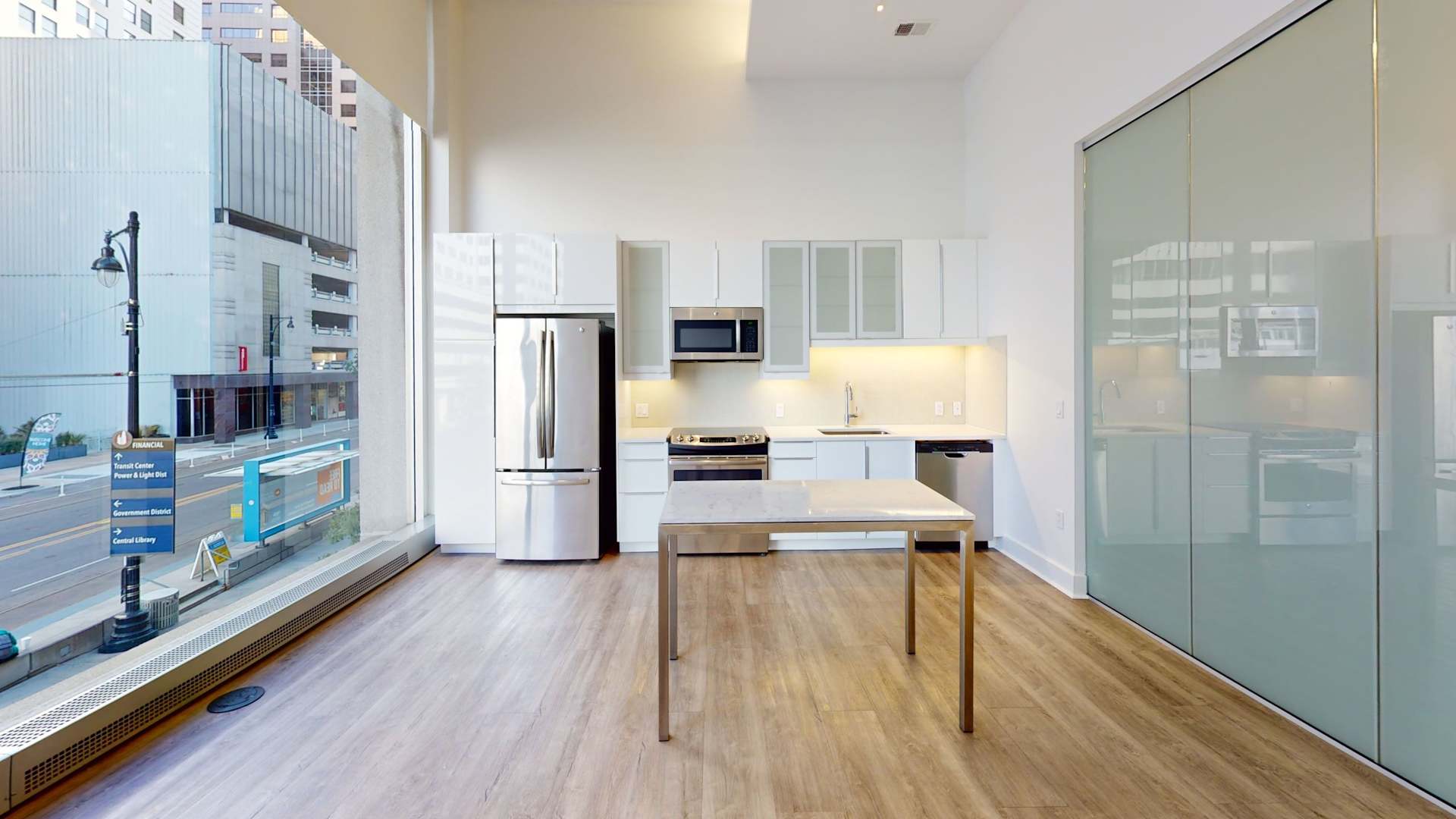 a kitchen with white counter tops and a stainless steel refrigerator