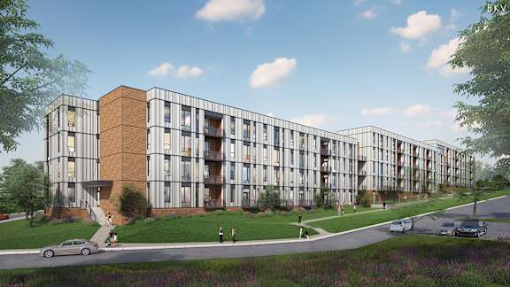 A modern apartment complex with a brick chimney on the first floor.