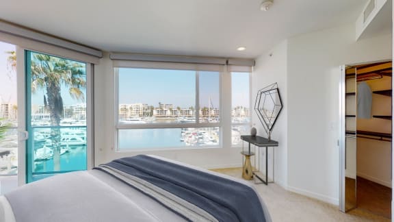 a bedroom with a bed and a window overlooking a body of water  at Esprit Apartments, Marina del Rey, 90292