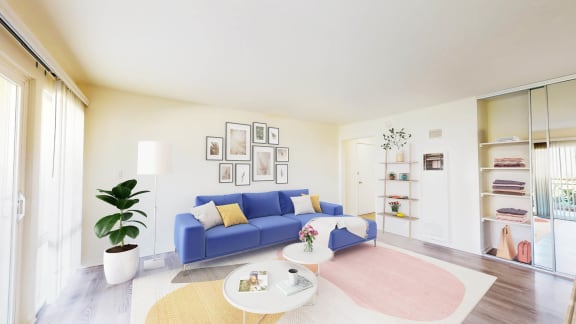 a living room with a blue couch and a pink rug at West Park Village, Los Angeles, California