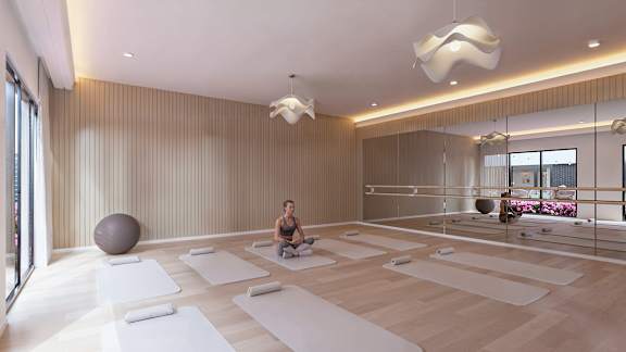 A yoga studio with a person sitting on a mat.