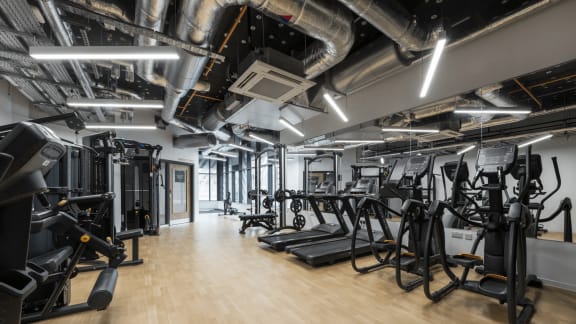 a gym with exercise equipment on the floor and a column