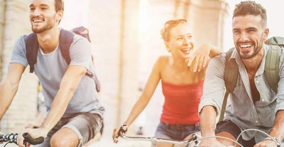 Three people riding bicycles together on a sunny day.