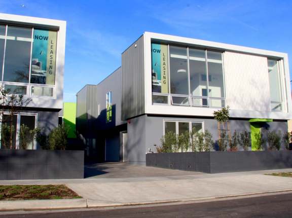 Two modern buildings with glass windows and greenery in front. at The Geffen, Los Angeles, CA