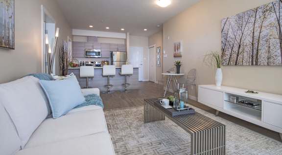 A living room with a white couch and a coffee table in the center.