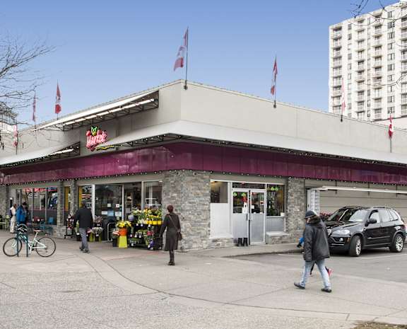 people walking in front of a store on a city street